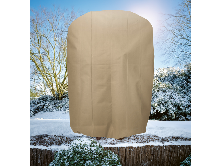 Housse de protection beige pour plantes dans un paysage hivernal enneigé.