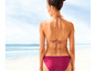 Une femme porte un bikini rose sur la plage.