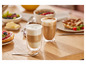 Deux verres de cappuccino sur une table en bois avec d'autres articles pour le petit-déjeuner.