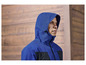 Un homme porte une veste bleue à capuche.