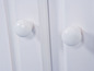 Deux boutons blancs sur une porte blanche.