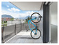 Un vélo Easymaxx bleu accroché au mur d'un balcon.