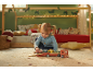 Petit enfant joue avec un camion jouet en bois avec des voitures dans une chambre d'enfant.