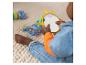 Bébé jouant avec un miroir et des jouets colorés sur un tapis texturé.