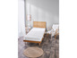Un matelas blanc sur un cadre de lit en bois dans une chambre lumineuse.