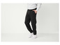 Un homme portant un pantalon de survêtement noir et des baskets blanches