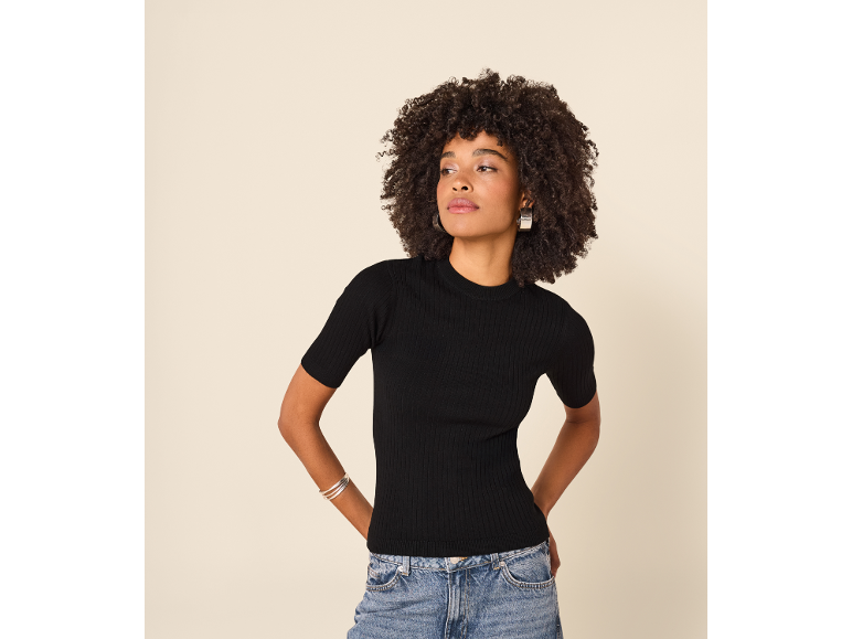 Femme portant un t-shirt en maille côtelée noire et un jean bleu