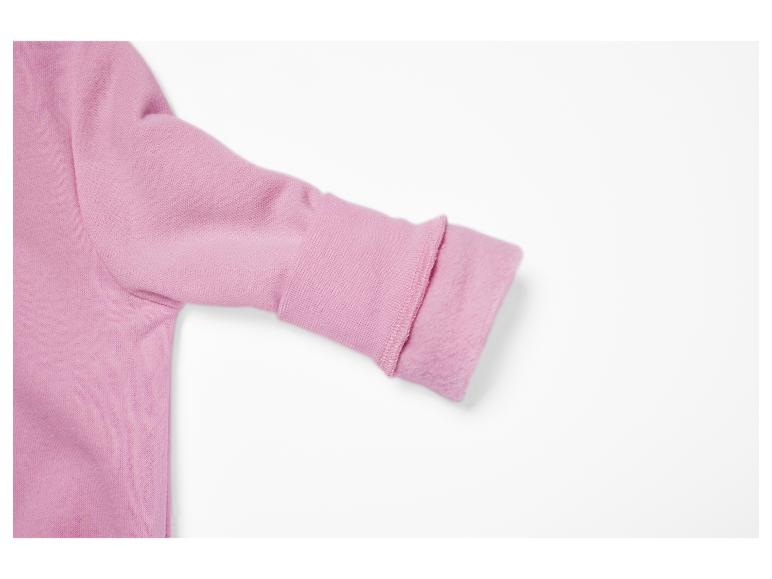 Manche rose d'un sweat-shirt ou d'un pull, avec le poignet retroussé pour montrer la doublure douce.