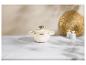 Marmite couleur crème avec un bouton en laiton, deux salières blanches et un set de table tressé sur une surface en marbre.
