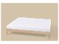 Un matelas blanc sur un sommier en bois clair, sur un fond beige.