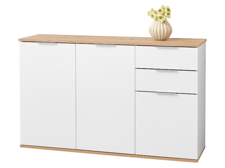 Buffet blanc avec tiroirs et portes, avec un plateau en bois clair et un vase de fleurs.