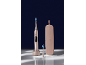 Brosse à dents électrique rose sur socle de chargement, tête de rechange et étui de voyage sur fond bleu foncé.