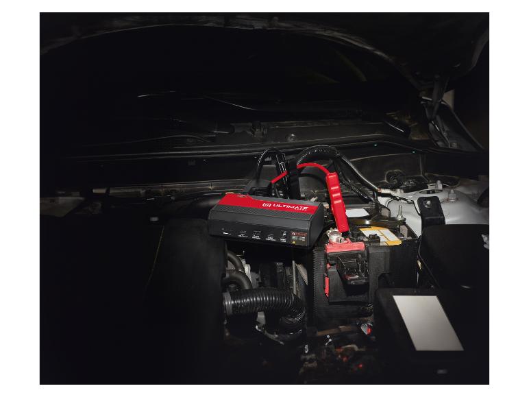 Démarreur de voiture Ultimate Speed et câbles de démarrage connectés à une batterie de voiture.