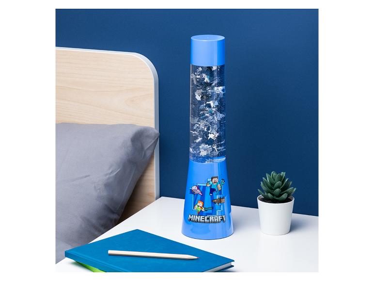 Lampe à lave bleue sur le thème du jeu vidéo, un carnet et un crayon sur une table de chevet.