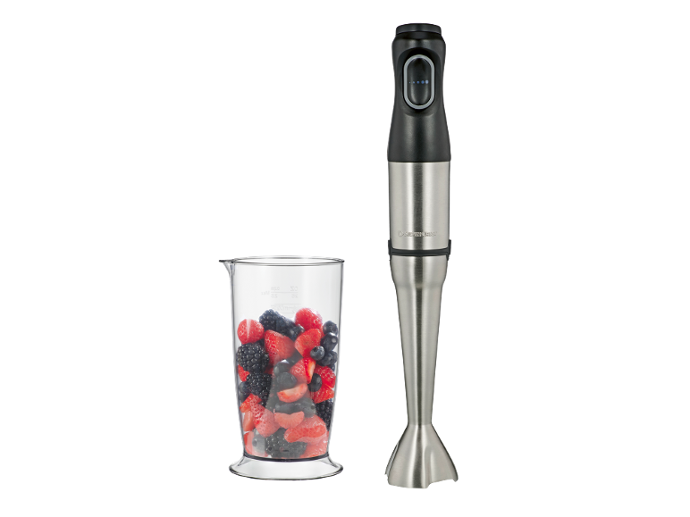 Mixeur plongeant en acier inoxydable à côté d'un verre doseur rempli de fruits rouges