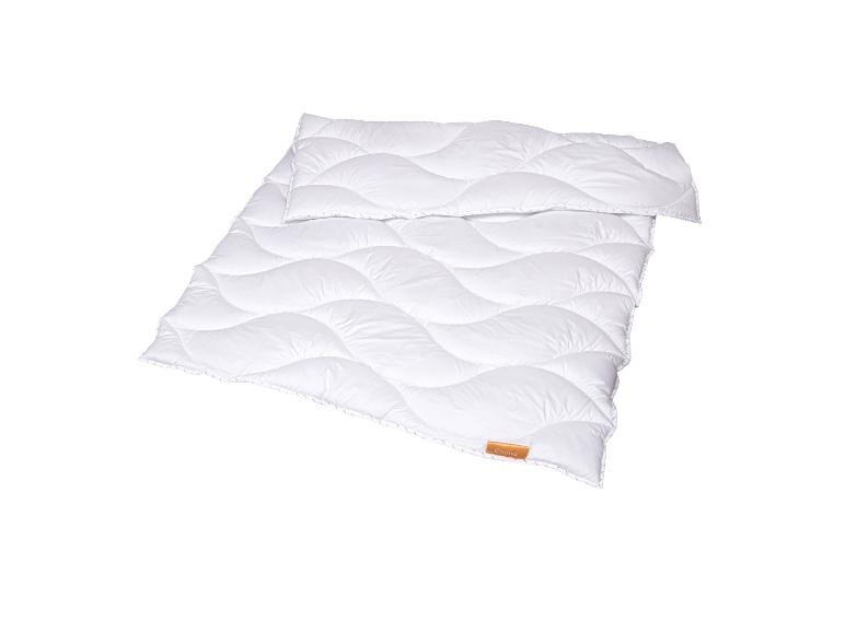 Couette blanche matelassée avec motif ondulé et petite étiquette marron