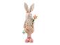 Un lapin de Pâques en peluche avec une fleur rose.