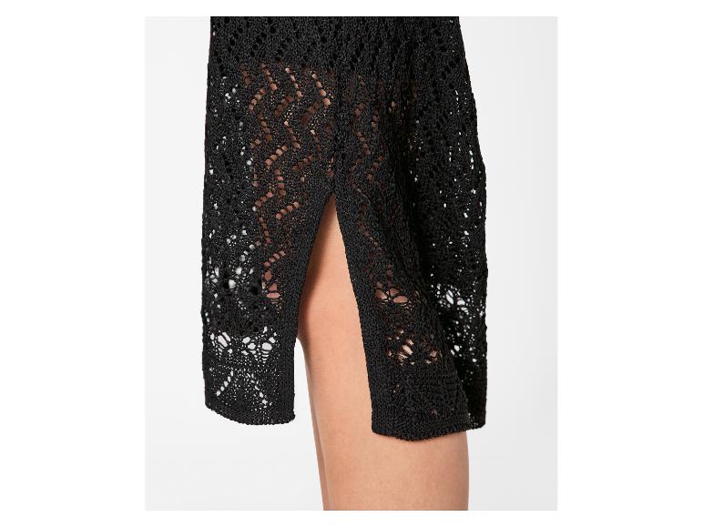 Détail d'une jupe en crochet noire avec fente latérale, montrant la jambe.
