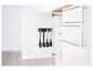 Ustensiles de cuisine, dont des spatules et des louches, accrochés à une bande magnétique sur une armoire de cuisine blanche.