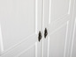 Deux portes blanches avec des poignées en laiton ornées.