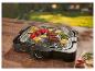 Grill électrique avec légumes et viande sur une table en bois à l'extérieur.