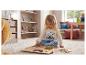 Fille en pyjama Stitch jouant avec un puzzle en bois sur un tapis.