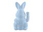 Un lapin en peluche bleu pâle assis avec une patte levée.
