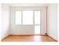 Niveau laser projetant des lignes rouges dans une pièce vide avec parquet.