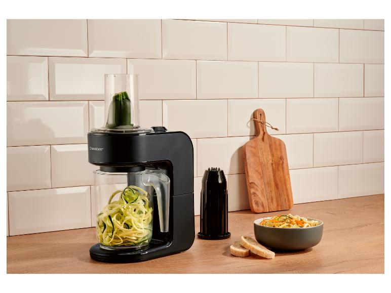 Spiraliseur électrique noir avec une courgette faisant des nouilles de courgette, et un bol de nouilles de légumes.