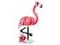 Flamant rose Lego avec des briques roses et blanches, des pattes noires et des fleurs tropicales sur une base.