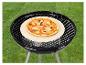 Pizza sur une pierre à pizza sur un barbecue noir.