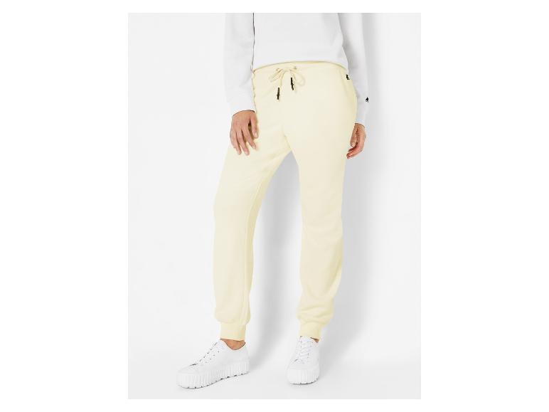 Pantalon de survêtement jaune clair avec des baskets blanches.