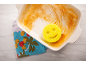Éponge jaune souriante dans un plat de cuisson sale avec un torchon.