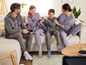 Une famille se relaxe sur un canapé en hoodies et joggings décontractés.