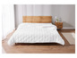 Couette blanche sur un lit en bois avec une table de chevet.