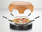 Un four à pizza Silvercrest avec un dôme en terre cuite et quatre mini pizzas