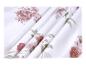 Tissu blanc avec motif floral de roses marron et feuilles vertes.