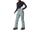 Femme en pull noir, pantalon de ski gris et casque blanc
