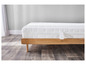 Un matelas blanc avec un cadre de lit en bois sur un sol en bois.