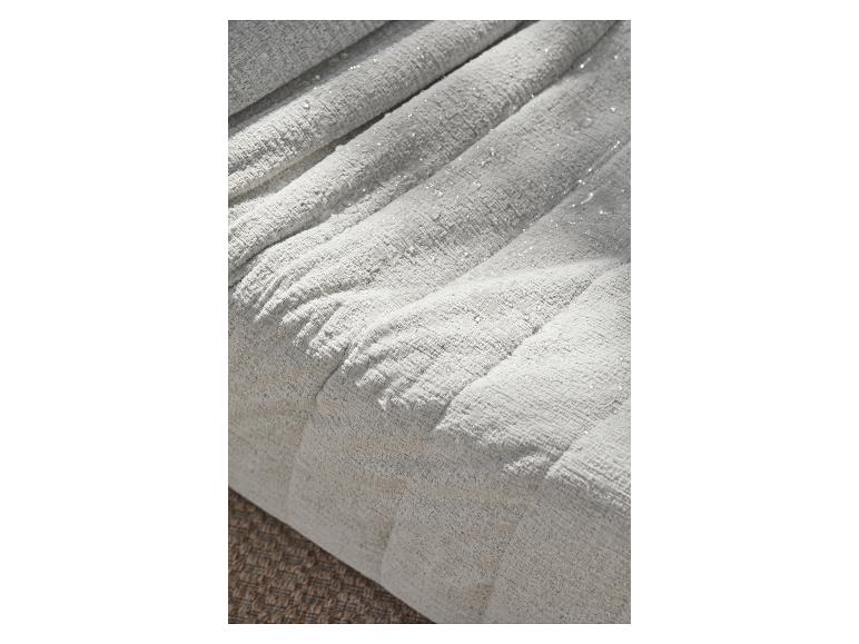 Gros plan d'un tissu gris clair texturé avec de subtils détails scintillants, peut-être résistant à l'eau.