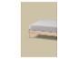 Un drap-housse gris clair sur un cadre de lit en bois sur fond beige.