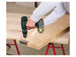 Une personne utilise un tournevis sans fil Parkside pour fixer une charnière à une planche de bois.