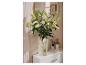 Vase en verre strié LIVARNO home avec des lys sur un meuble blanc.