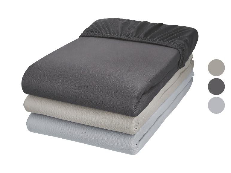 Ensemble de draps housses en coton gris foncé, beige et gris clair.
