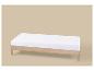 Lit simple en bois clair avec matelas blanc sur fond beige.