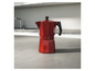 Une cafetière rouge sur un comptoir.