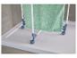 Séchoir à linge portable avec une serviette verte sur un receveur de douche blanc.