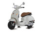 Un scooter Vespa blanc avec une selle marron.