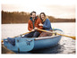 Un couple dans un bateau bleu ramasse sur un lac.