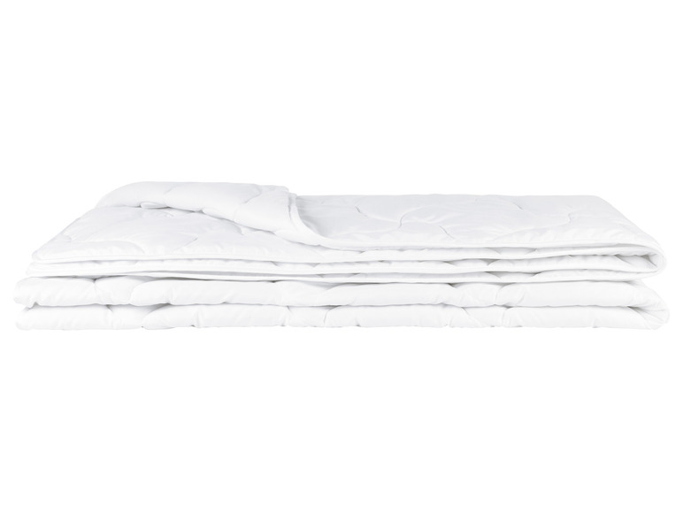 Une couette blanche pliée et prête à l'emploi.
